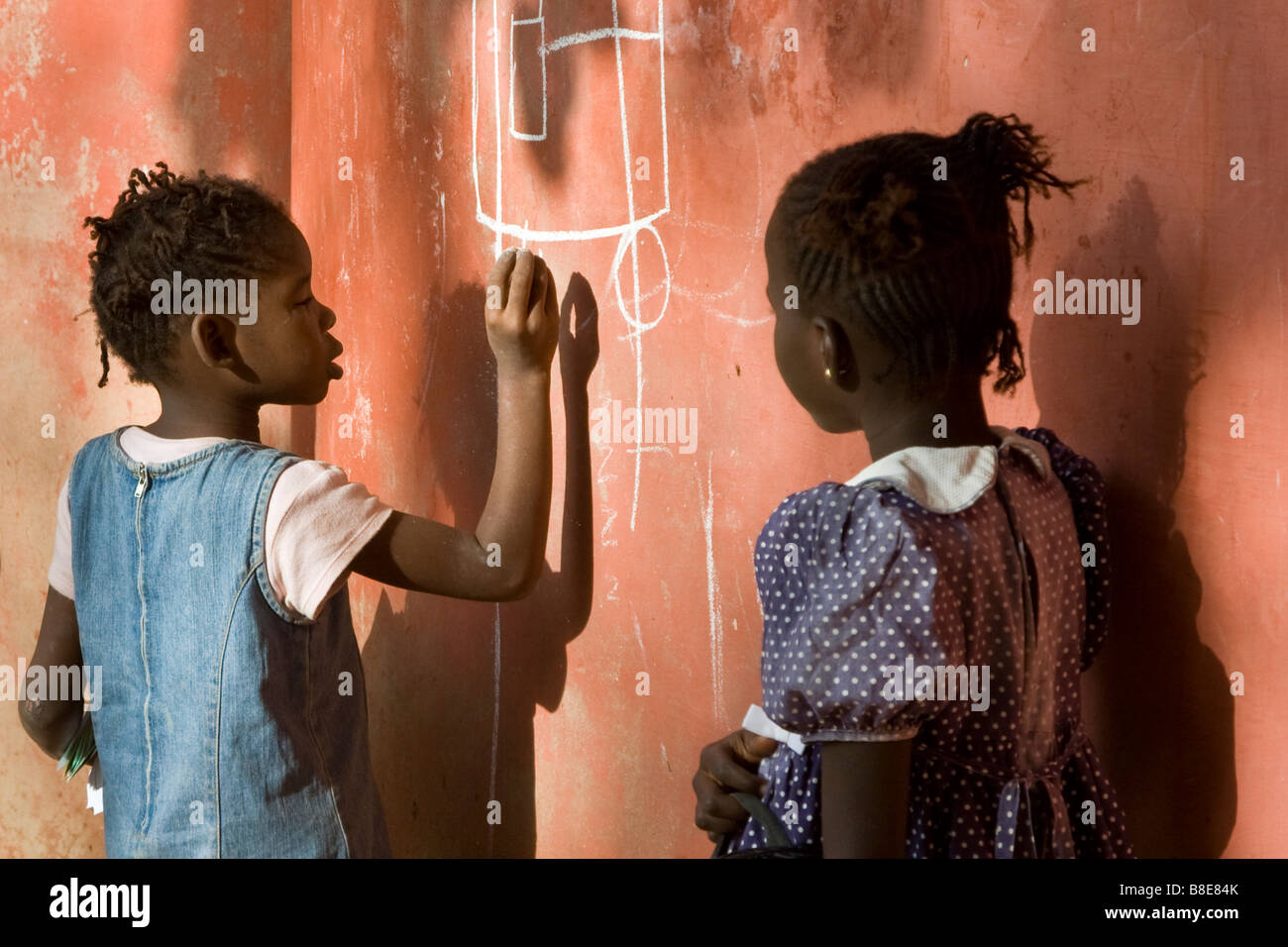 Senegalese Girl Writing on a Wall with Chalk on Ile de Goree in Senegal West Africa Stock Photo