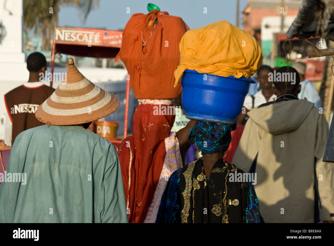 Women Carrying Bundles Balanced on their Heads in St Louis in Senegal West Africa Stock Photo