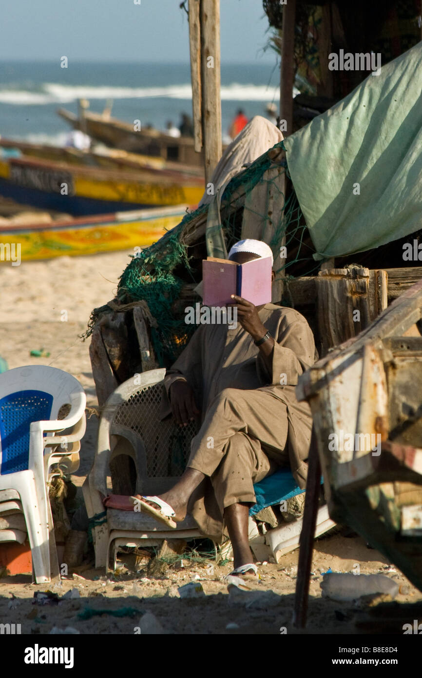 Muslim Man Reading on the Beach in St Louis in Senegal West Africa Stock Photo