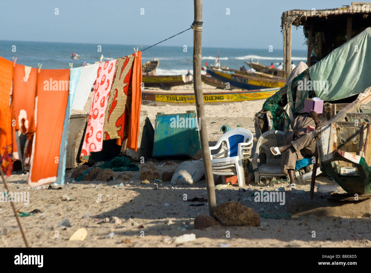 Muslim Man Reading on the Beach in St Louis in Senegal West Africa Stock Photo