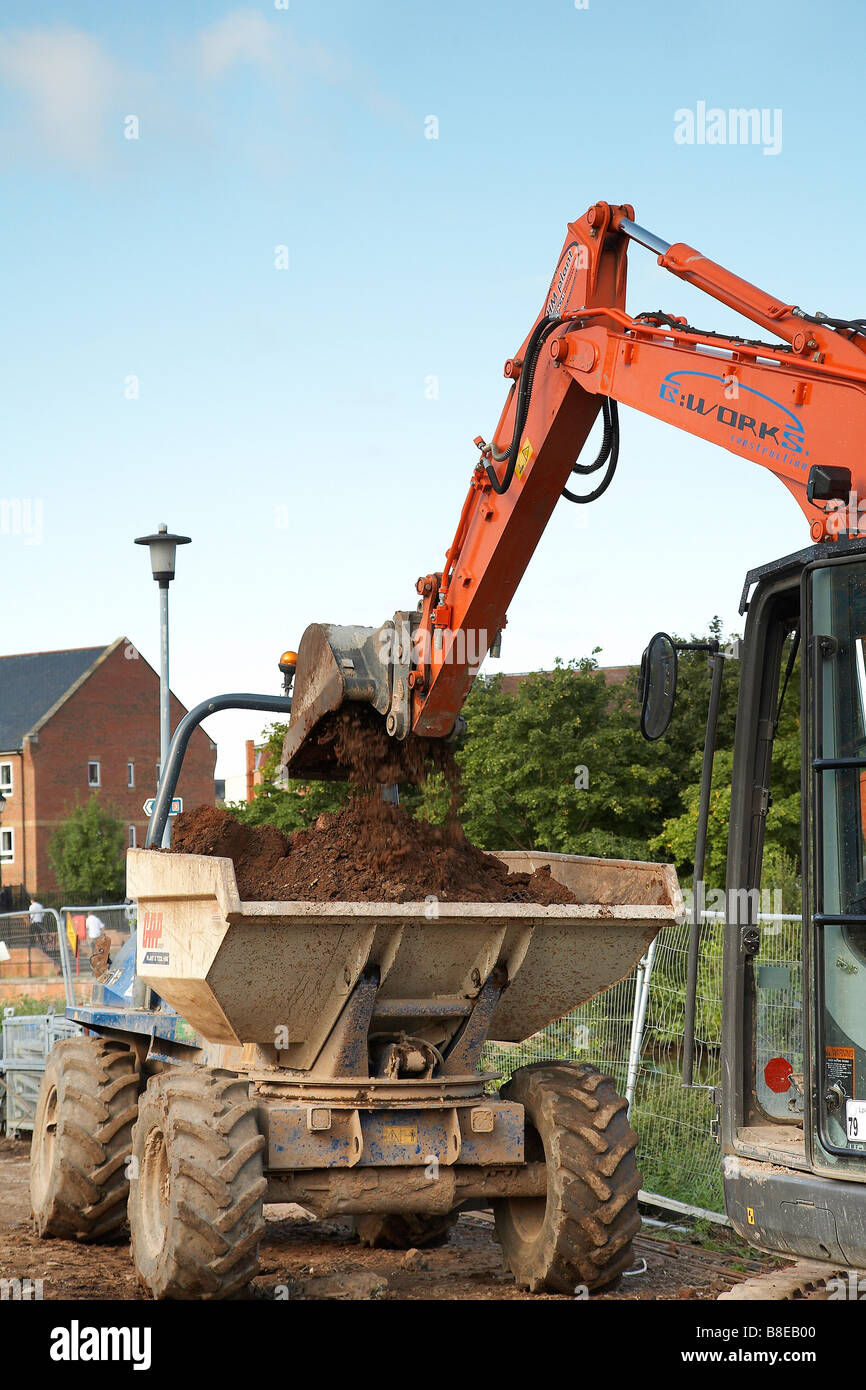 Construction of new apartments at taunton cricket club. Jcb loading a dump truck with earth Stock Photo