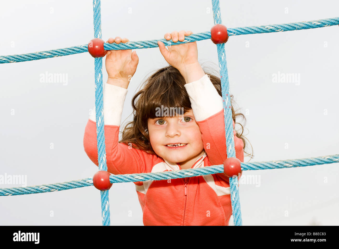 Little girl 3 years old climbing on net Stock Photo