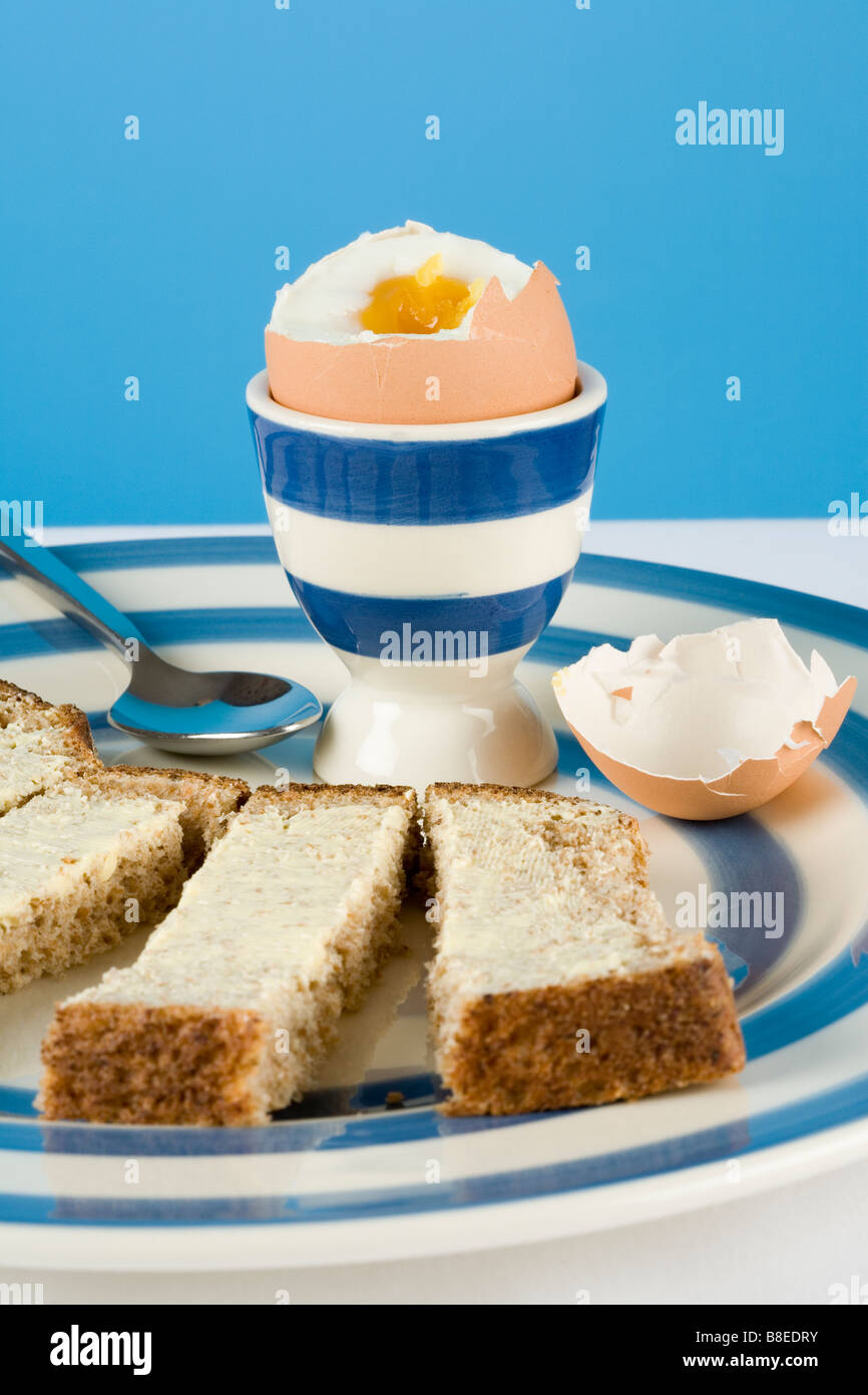 A boiled egg and buttered bread fingers or soldiers Stock Photo