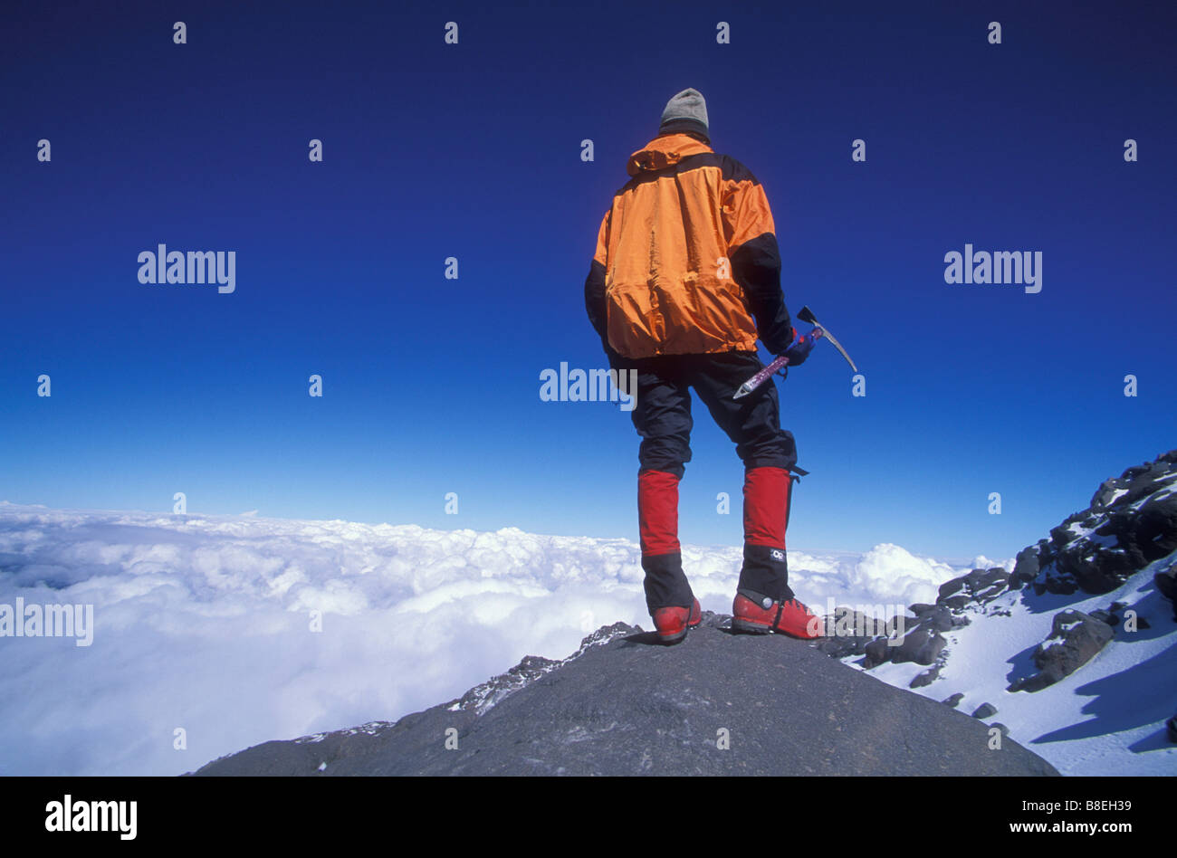 Mountain climber enjoys the view in distance while standing on El Pico de Orizaba in Mexico Stock Photo