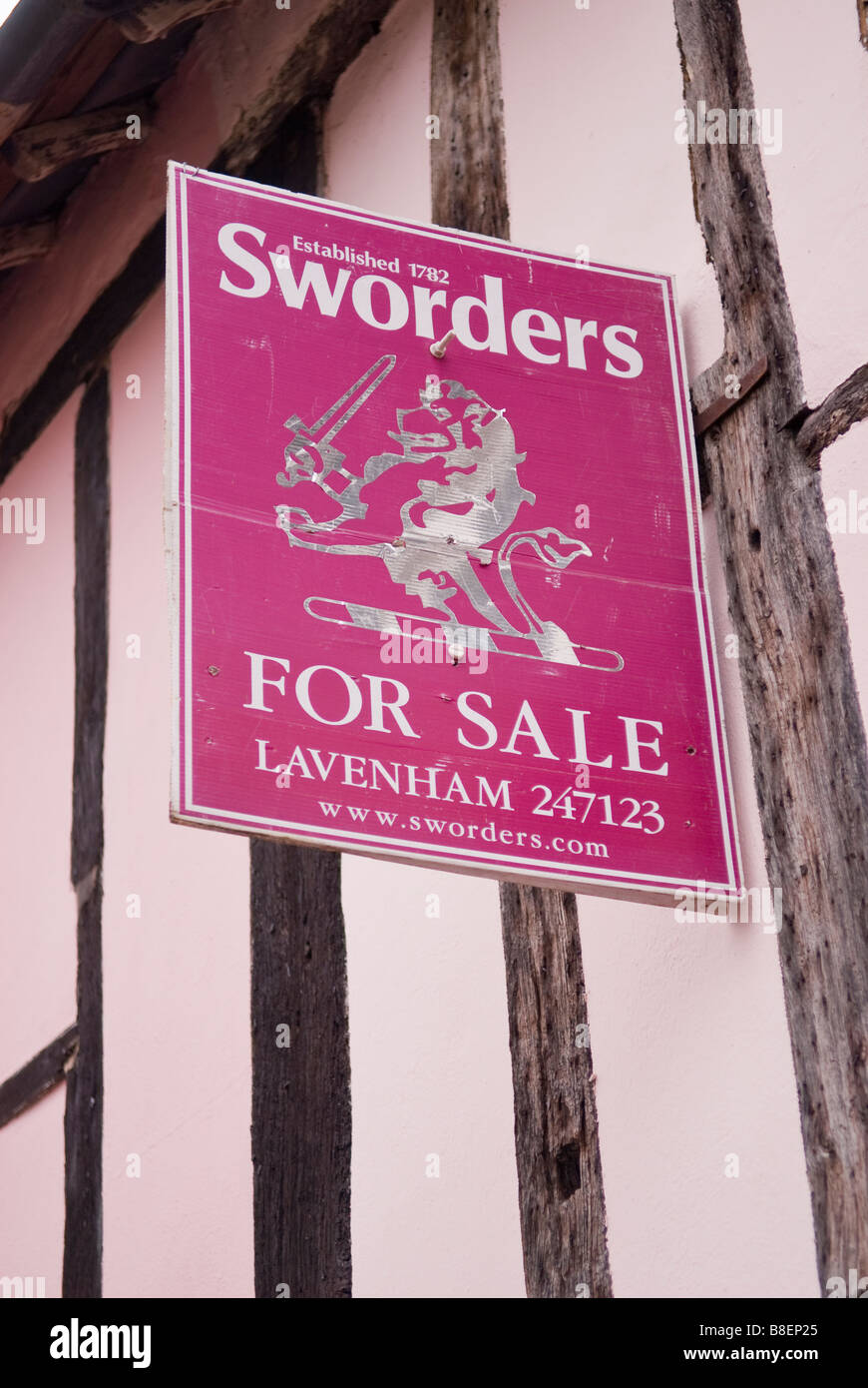 A for sale sign by Sworders the estate agent on a tudor house in