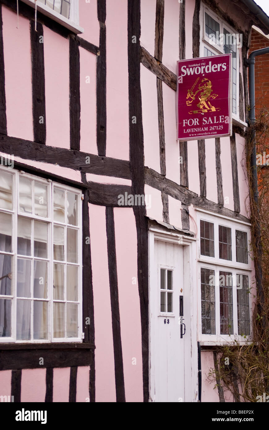 A for sale sign by Sworders the estate agent on a tudor house in