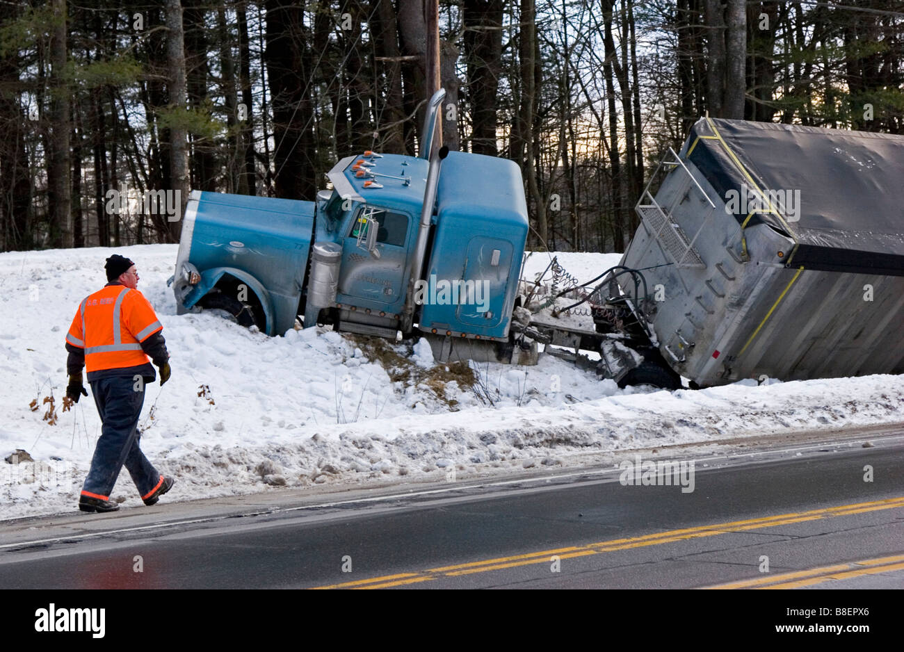 Semi truck in ditch in snow with a man looking on Stock Photo Alamy