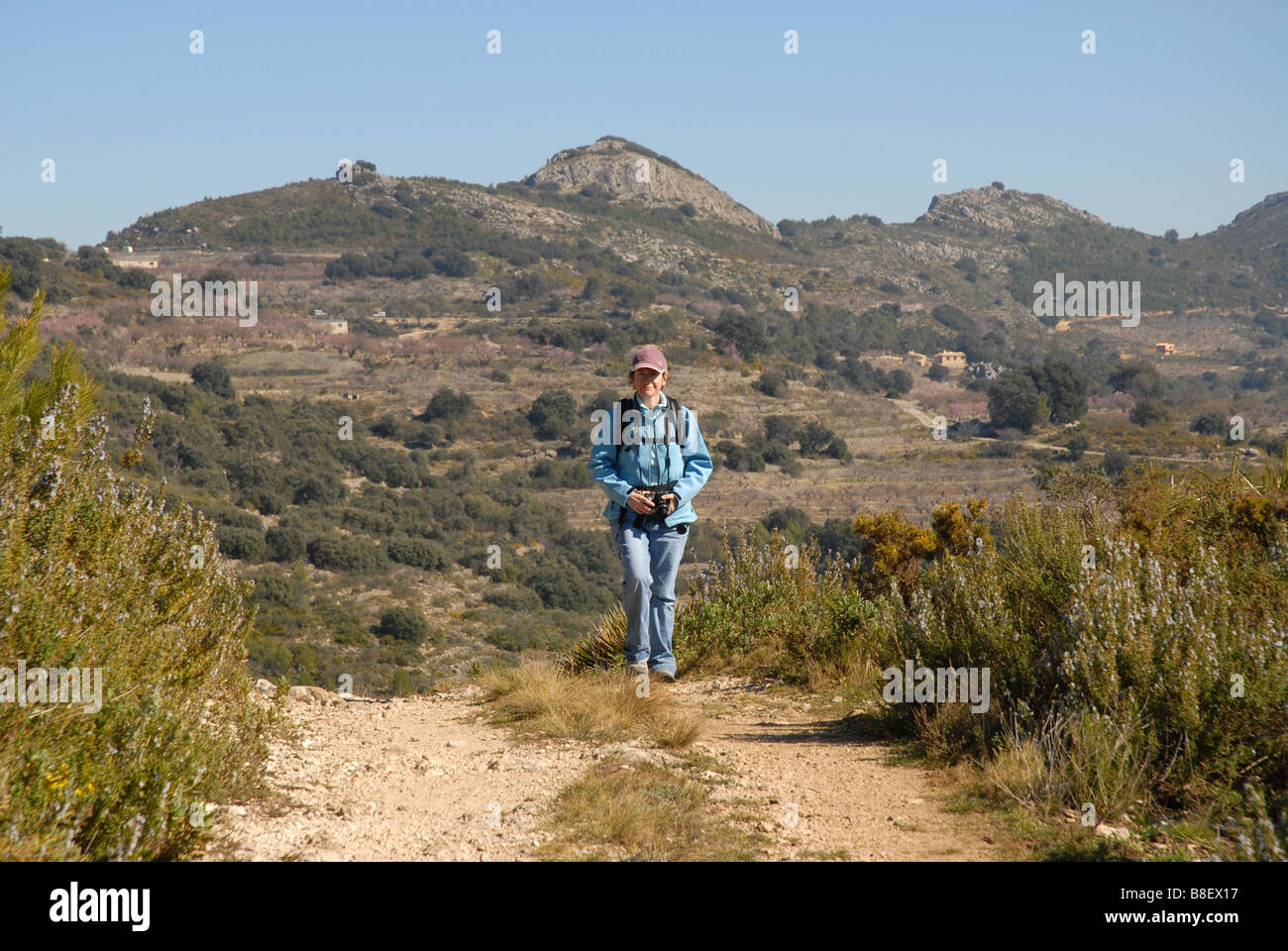 woman hiking on mountain track, near Benimaurell, Vall de Laguar, Alicante province, Comunidad Valenciana, Spain Stock Photo