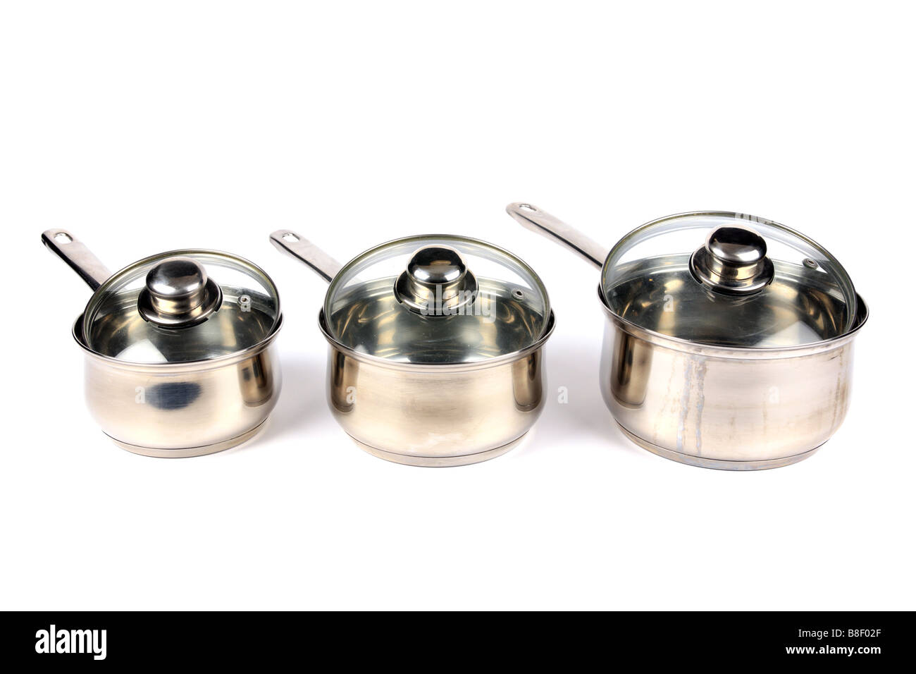 Three Stainless Steel Saucepans with glass lids against a white