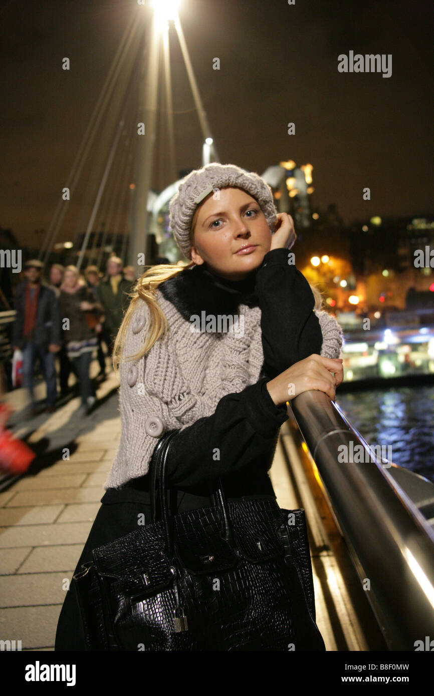 Blonde Ukrainian Girl Wearing Winter Clothes Standing on the Millennium Footbridge at Night Stock Photo