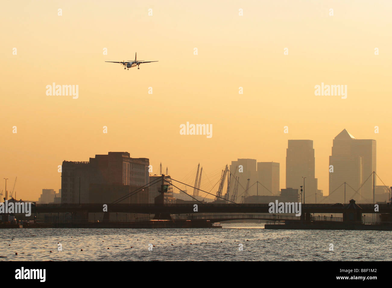 Regional airliner landing at London City Airport with Canary Wharf Docklands in the background, UK Stock Photo