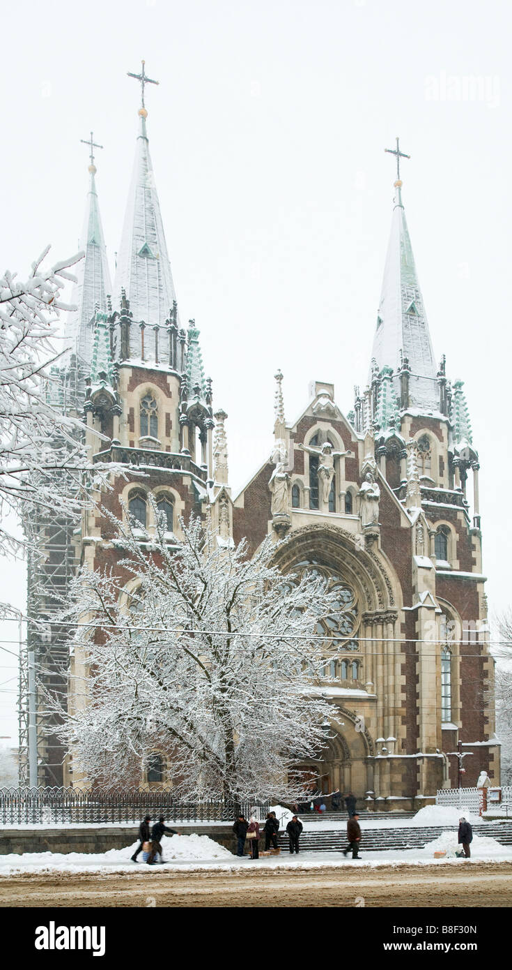 Winter dull snowfall day church view and big snow covered tree near St. Olga and Elizabeth church (Lviv, Ukraine) Stock Photo
