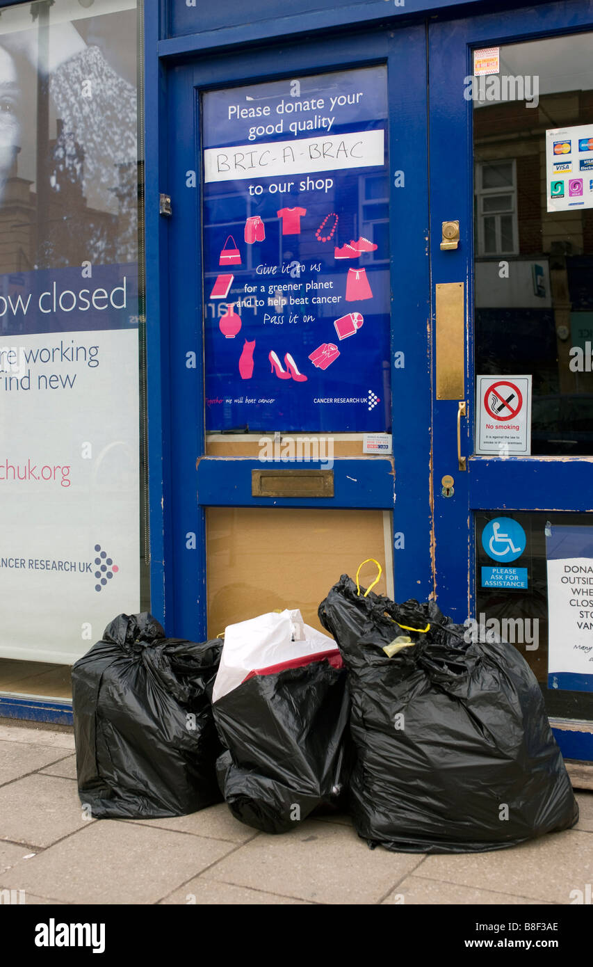A Cancer Research Charity shop with donations left in black bags