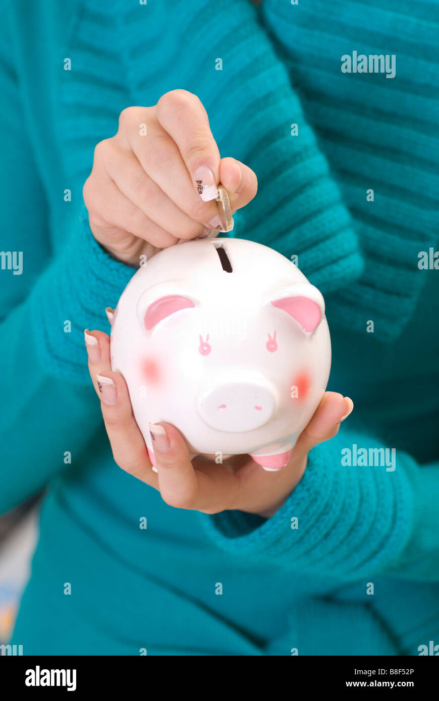 Woman saving money in piggy bank Stock Photo - Alamy