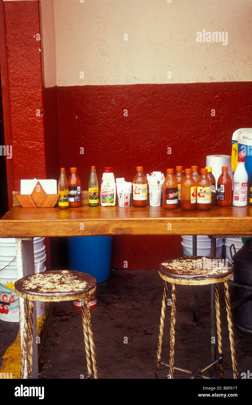 Bottles of Mexican hot sauce on the counter of a comedor restaurant in
