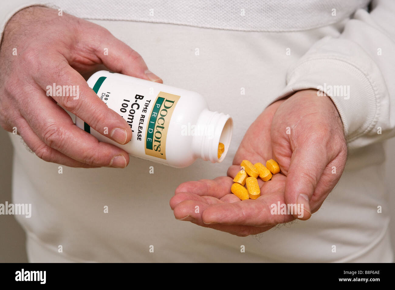 A person getting vitamins out of the bottle Stock Photo