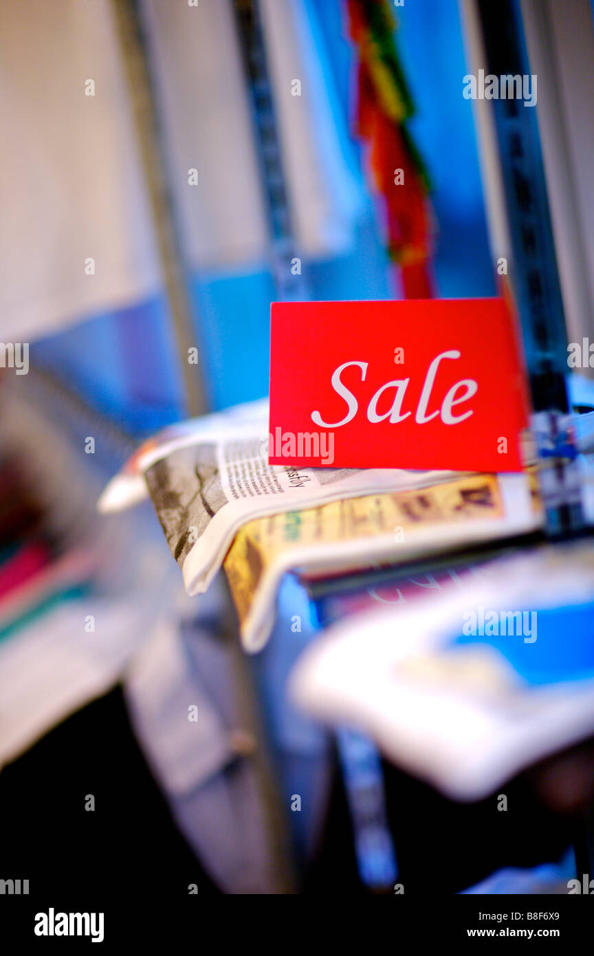 Red and white Sale sign on top of clothes in a store selective focus Stock Photo
