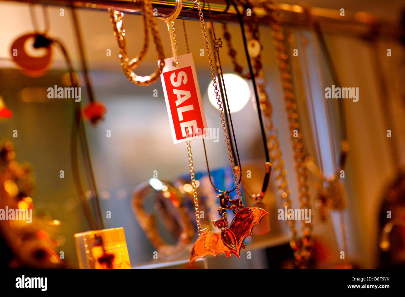 Red and white Sale sign hanging among necklaces in a store Stock Photo
