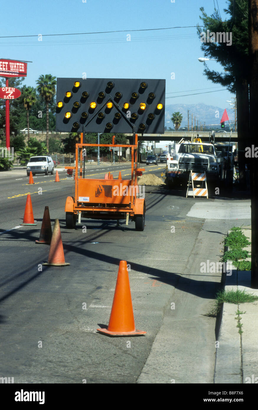 Highway sign with flashing arrow lights warns drivers of closed lane in