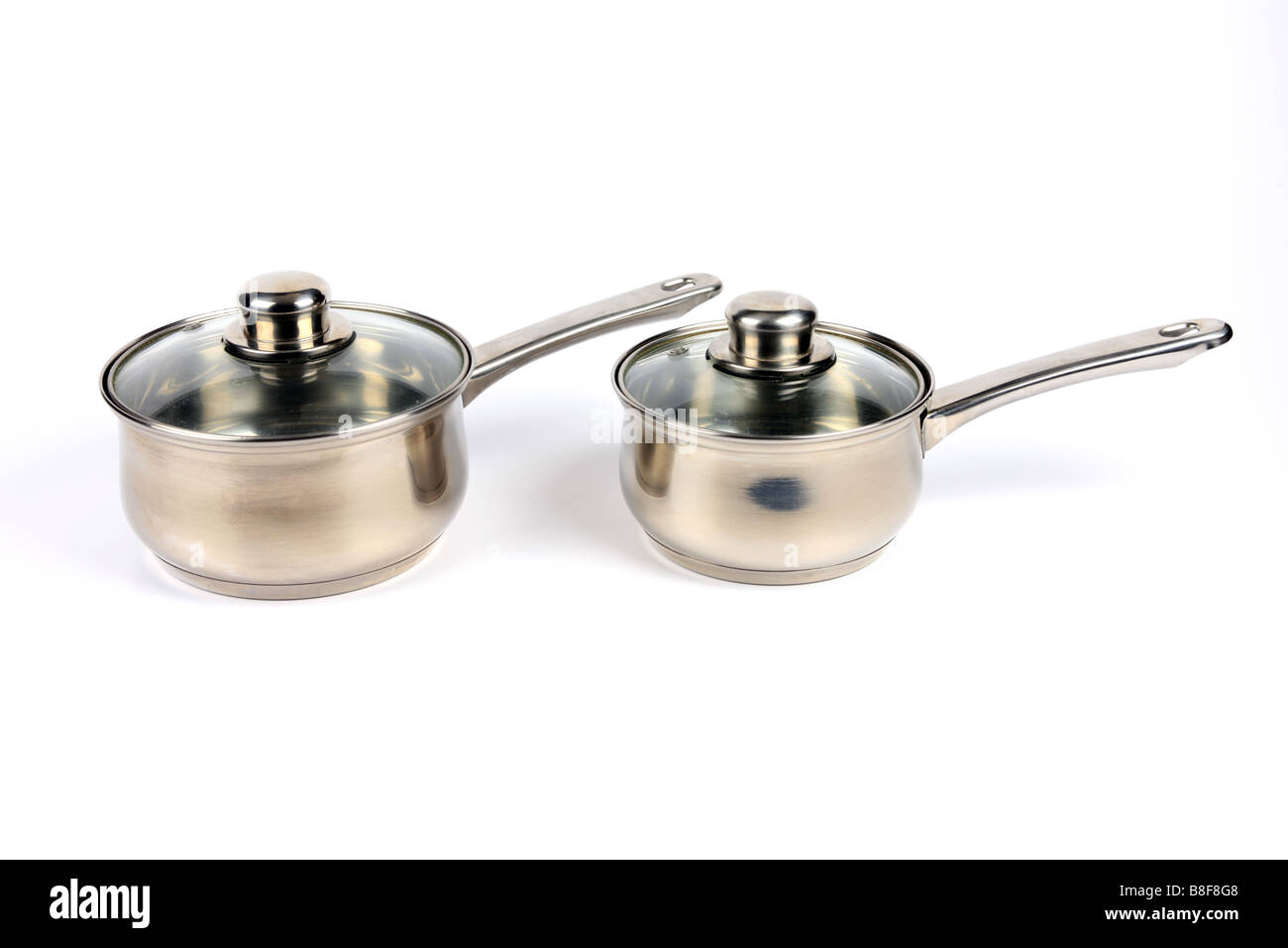 Two Stainless Steel Saucepans with glass lids against a white