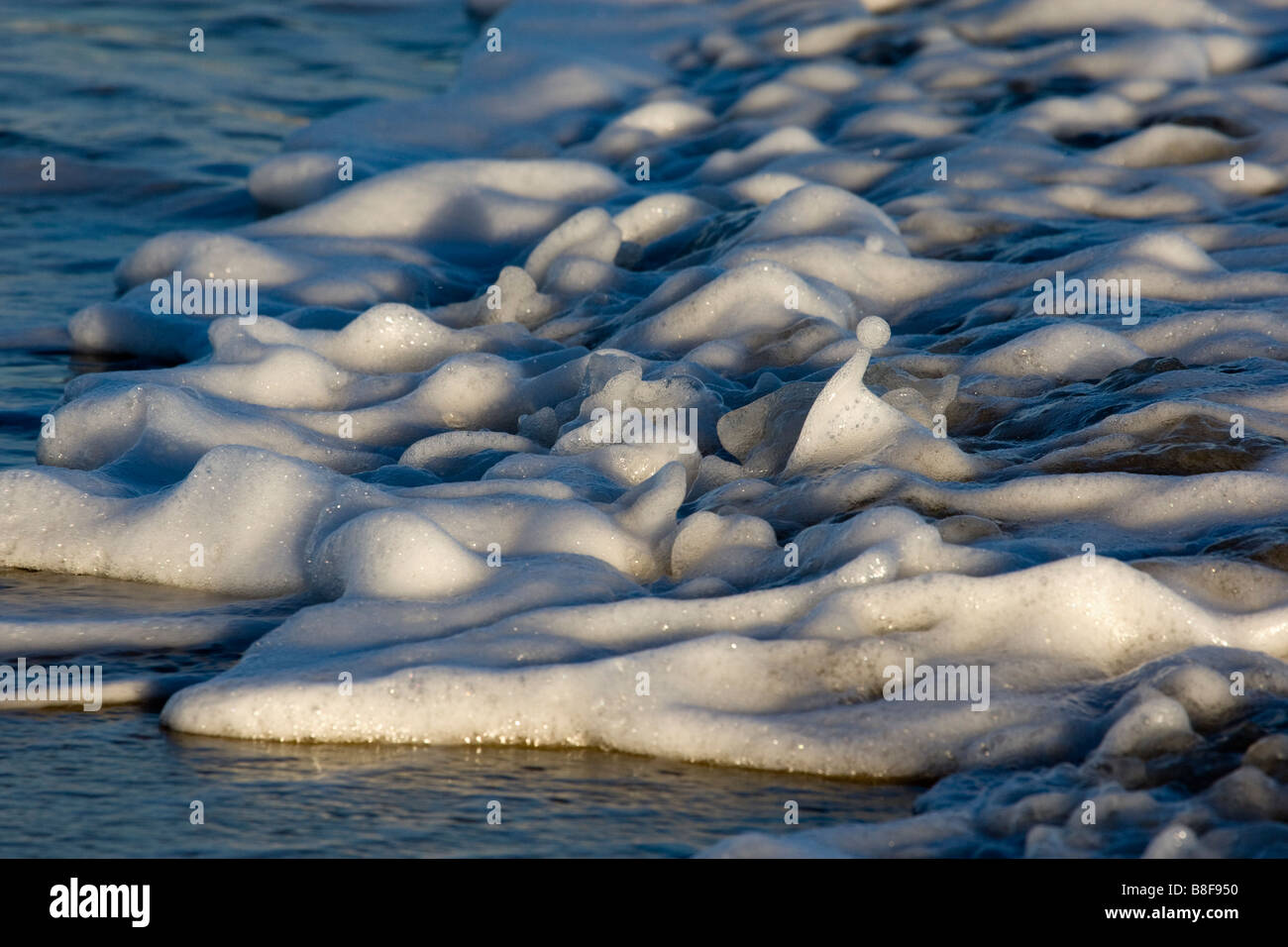 Rippling waters edge on an incoming tide Stock Photo