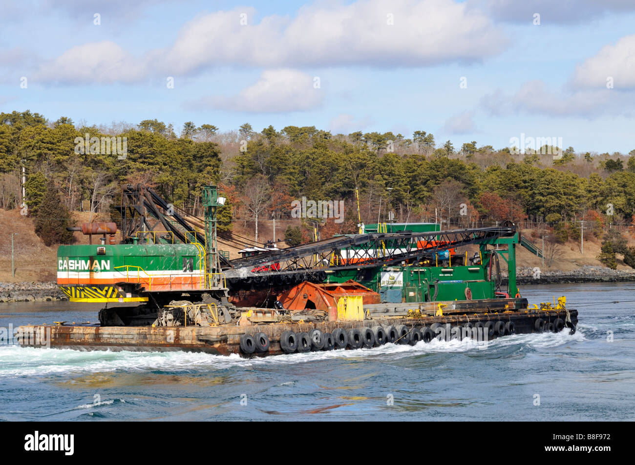 Crane and heavy equipment from Cashman Company being transported by barge in the 'Cape Cod Canal' Stock Photo