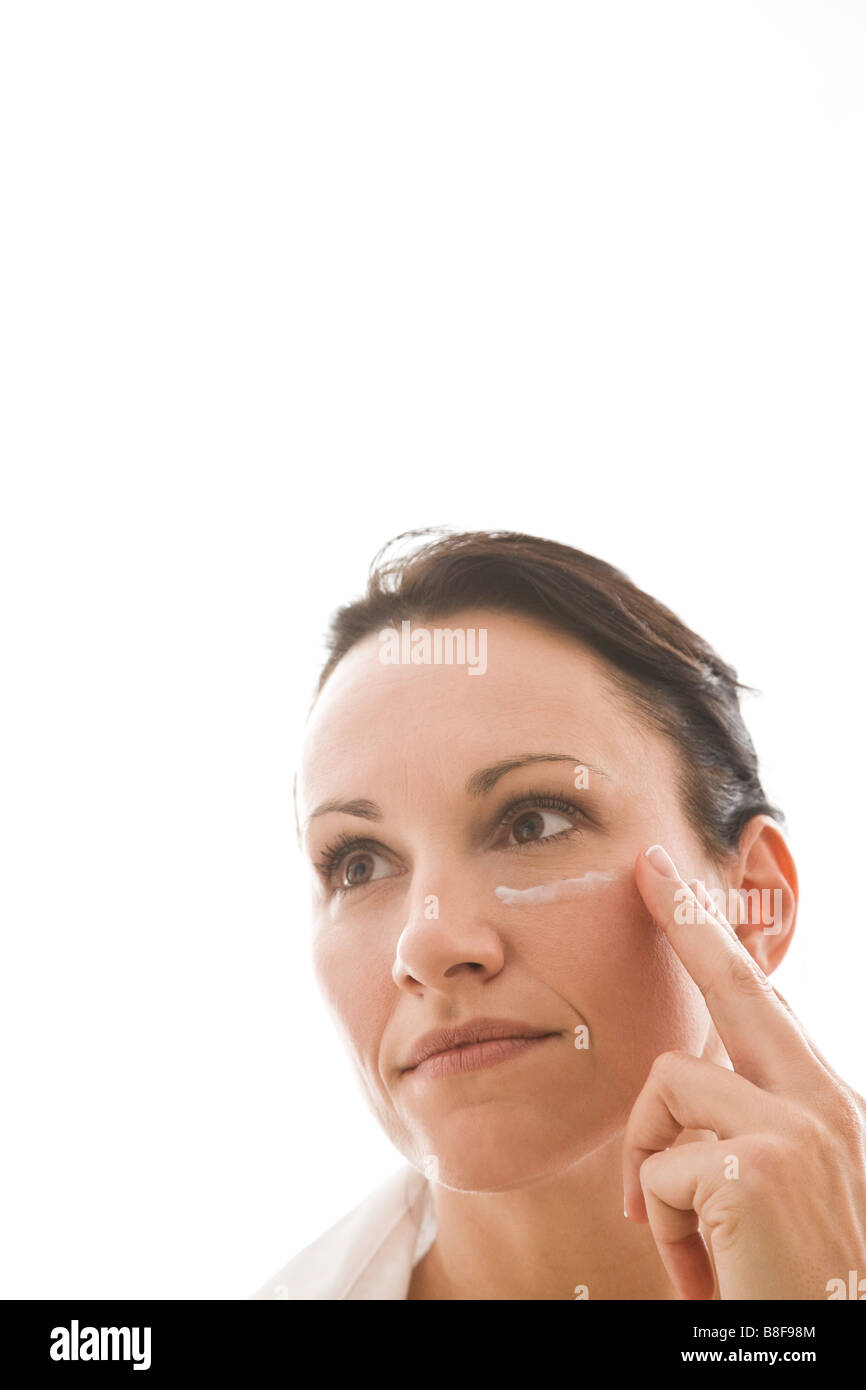 woman applying face cream Stock Photo