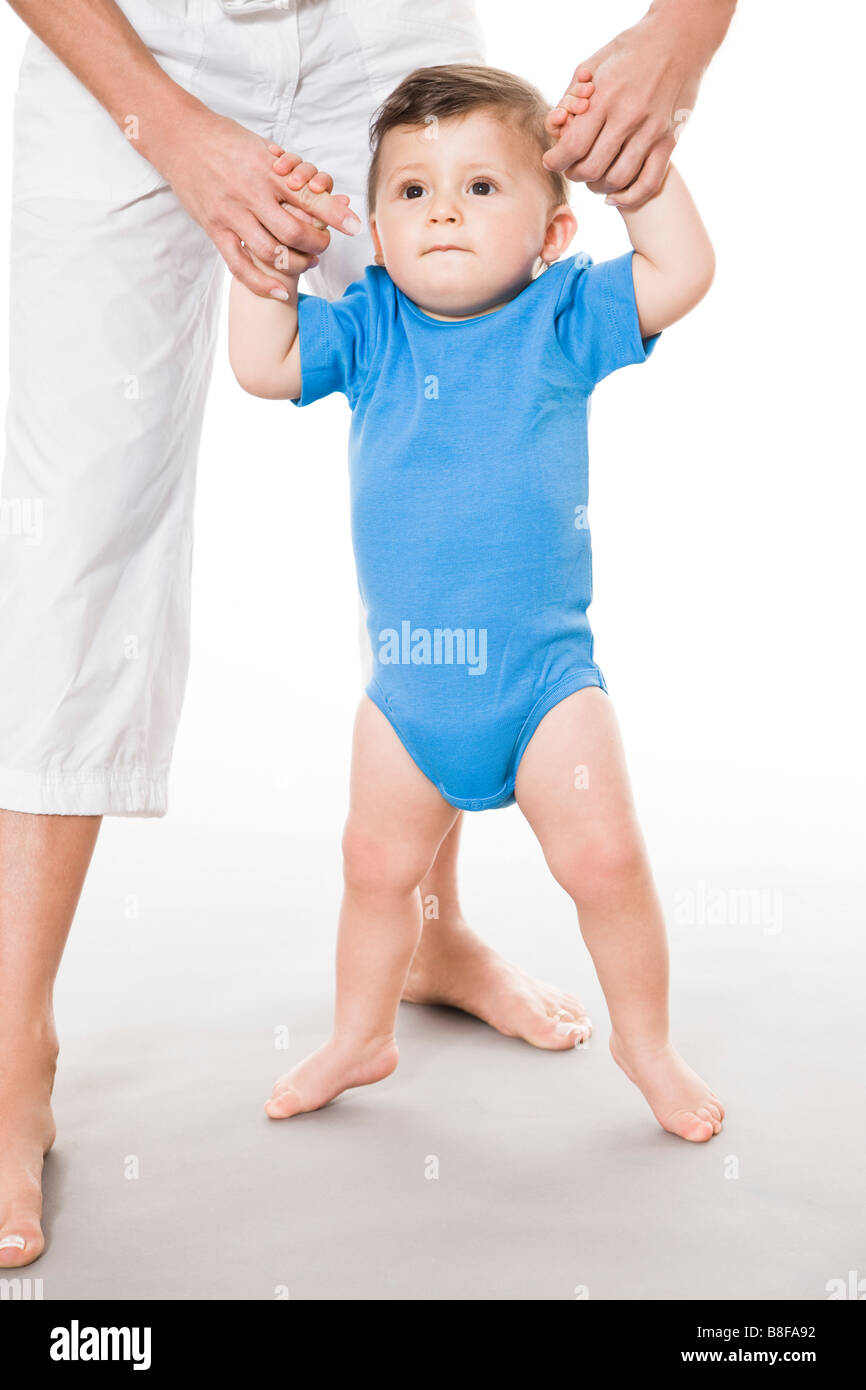 Mother teaching baby boy how to walk Stock Photo