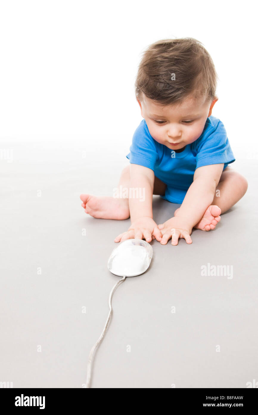 Baby on floor playing with computer mouse Stock Photo - Alamy