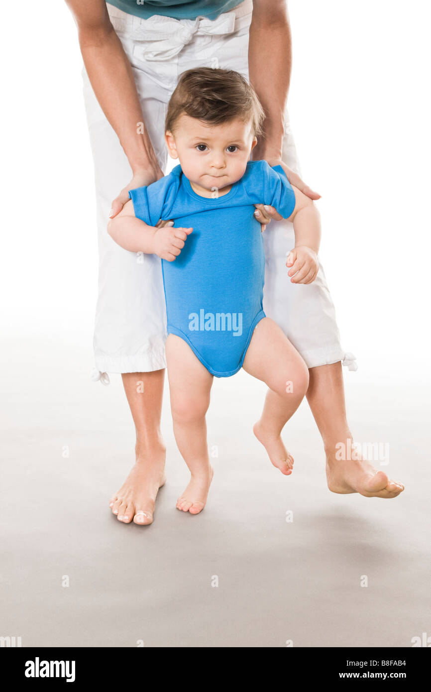 Mother teaching baby boy how to walk Stock Photo