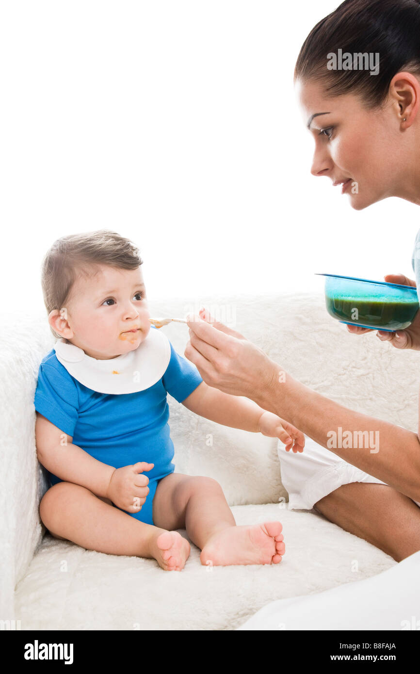 mother feeding baby with spoon Stock Photo Alamy