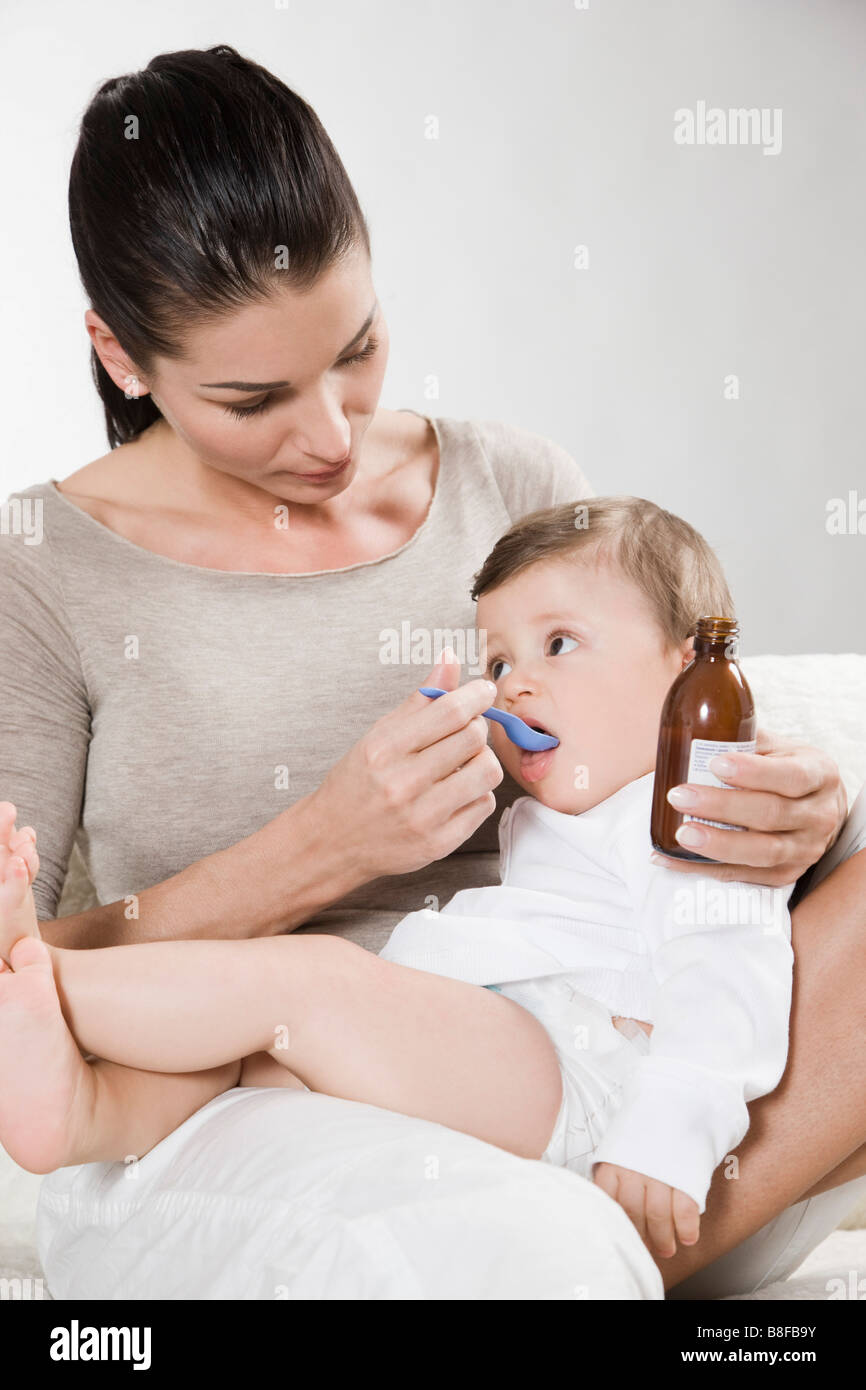 Mother gives medicine to sick baby Stock Photo