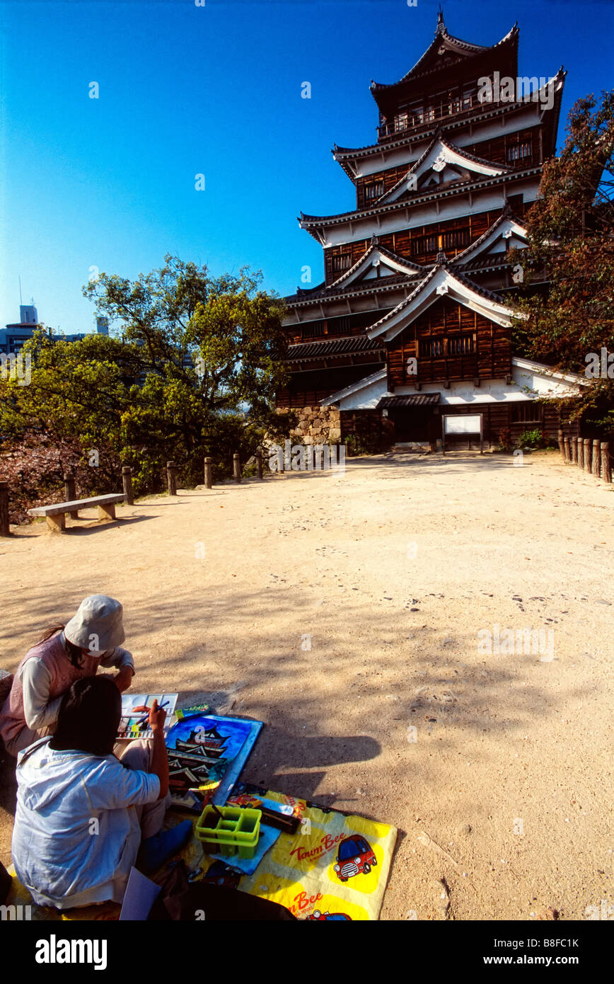 Two children paint pictures of Hiroshima Castle sometimes known as Carp Castle in Hiroshima Japan Stock Photo