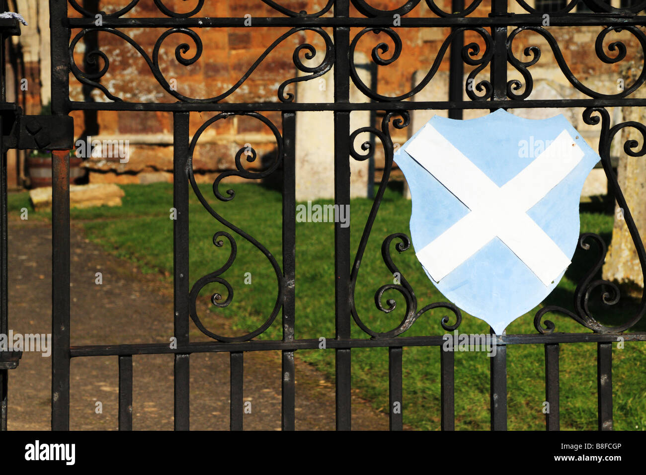 Wrought iron church gates with the cross of St Andrew shield in front Stock Photo