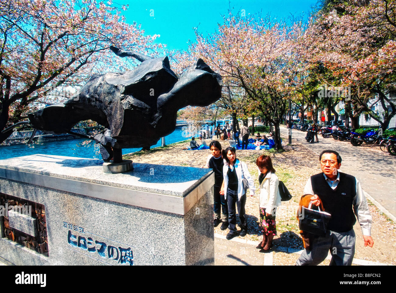Visitors look at the Hiroshima Peace Monument which is located in the Hiroshima Peace Memorial Park in Hiroshima Japan. Stock Photo