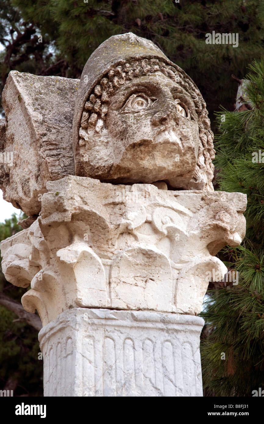 A fearsome sculpted warrior's head posed on a pillar in the Punic quarter of Tunisia's Carthage ruins Stock Photo