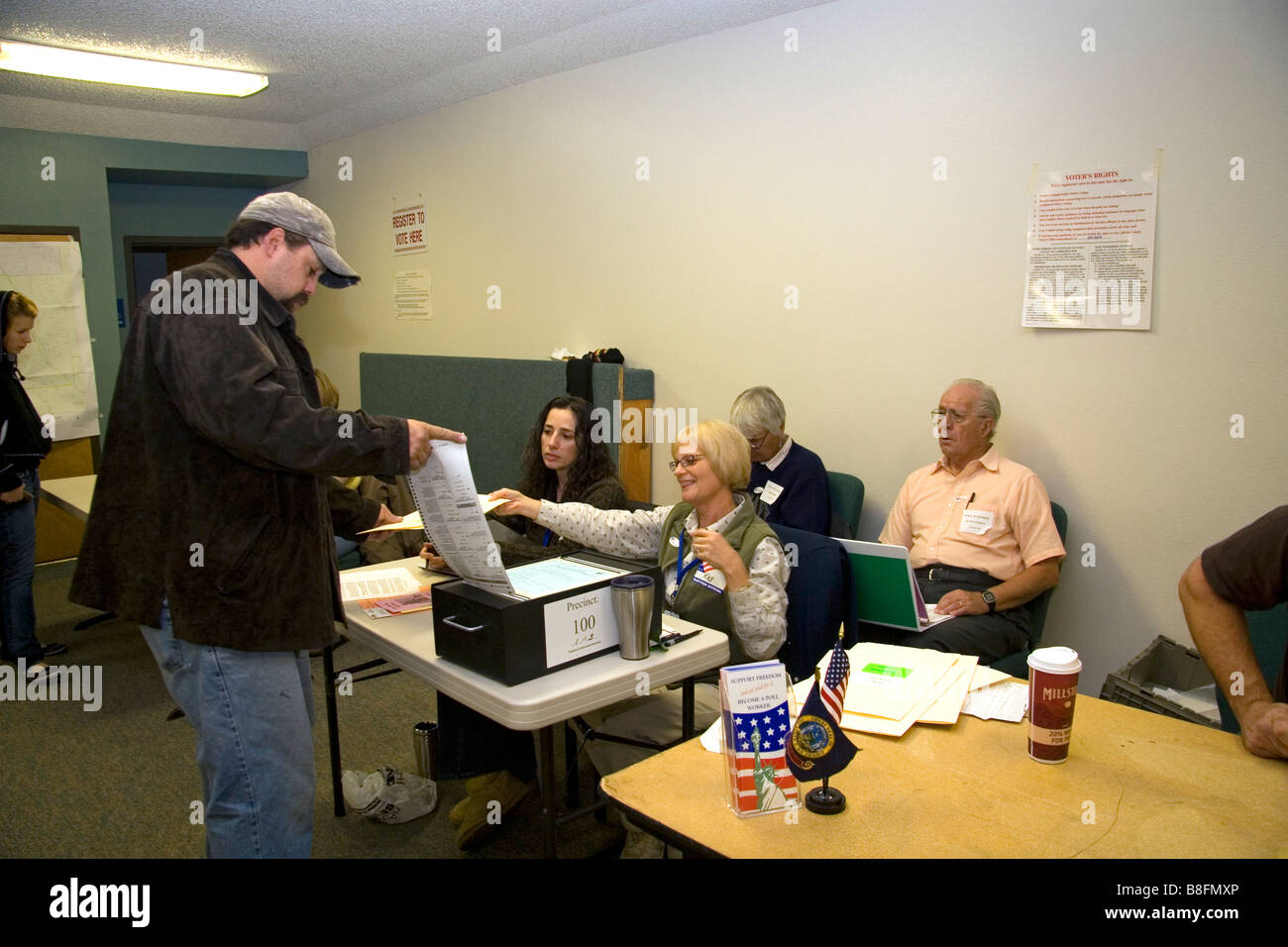Voter putting paper ballot into a ballot box at a polling station in Boise Idaho USA Stock Photo