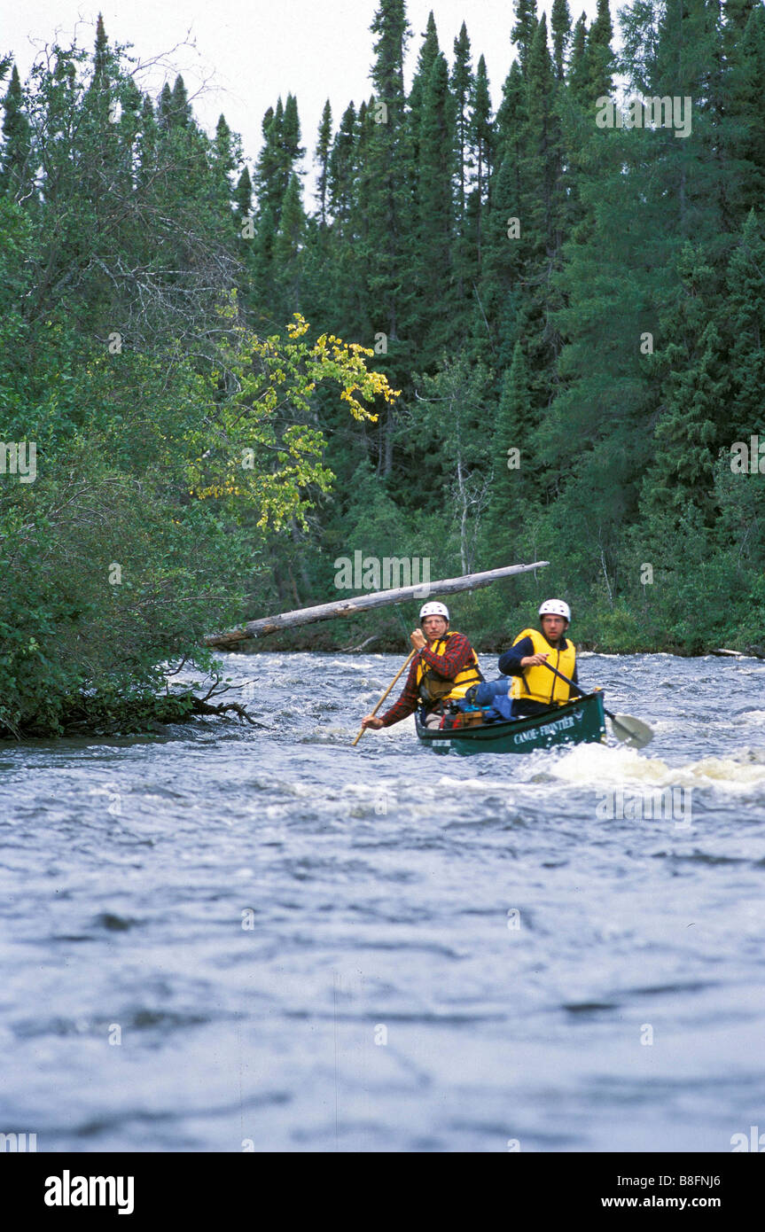 Two men paddle the rapids of the Ashweig River in far north of Ontario ...