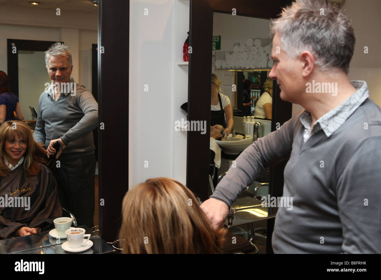 A Portrait Of A Male Hairdresser Working On Cutting A Woman S