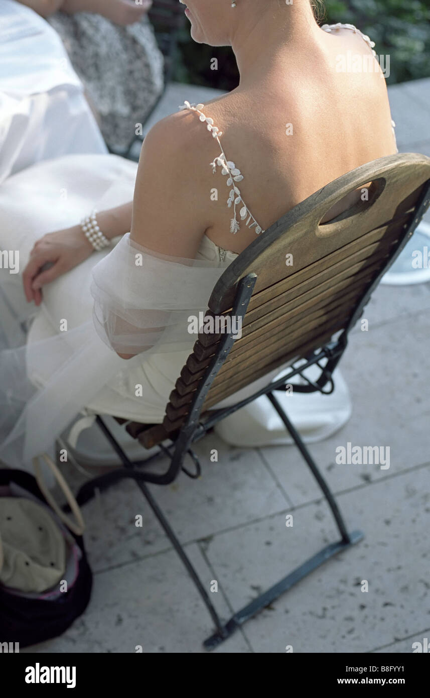 Bride sitting on a wooden Chair - Garden - Wedding Stock Photo