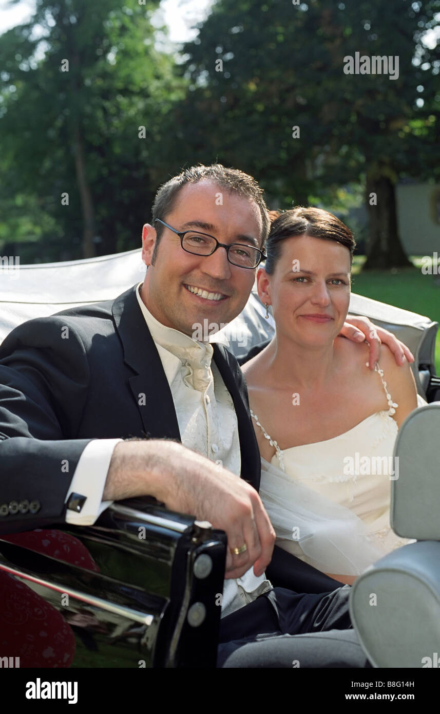 Bride and Bridegroom on the Backseat of a Vintage Car Automobile
