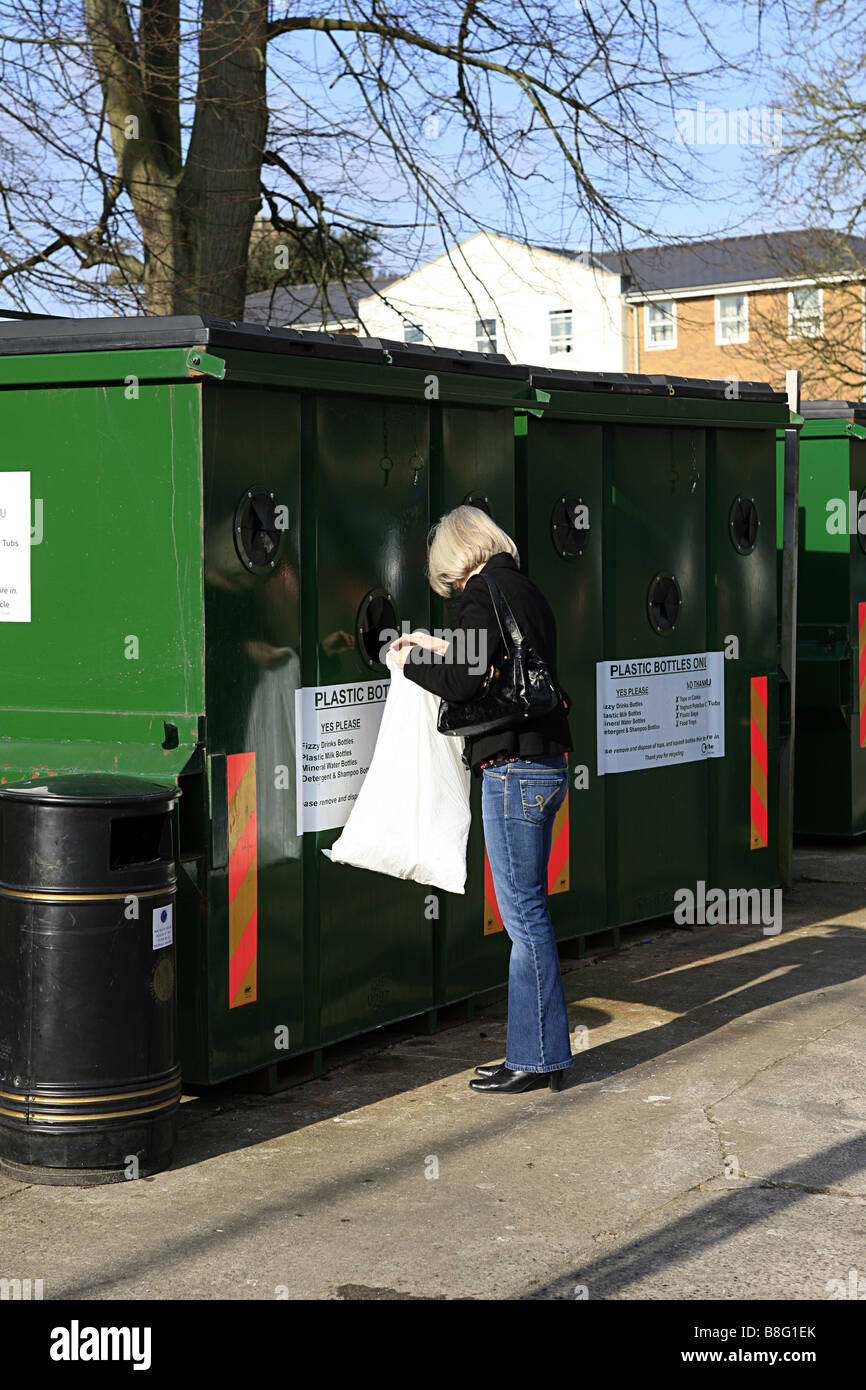 An adult female placing plastics from a carrier bag into a recycling