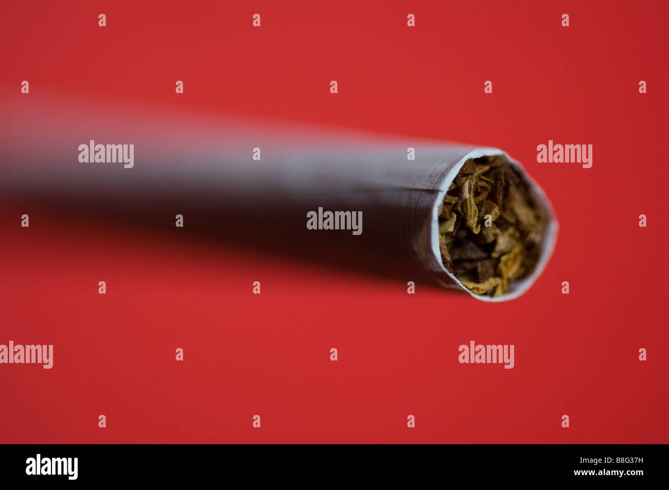 A cigarette on a red background Stock Photo - Alamy