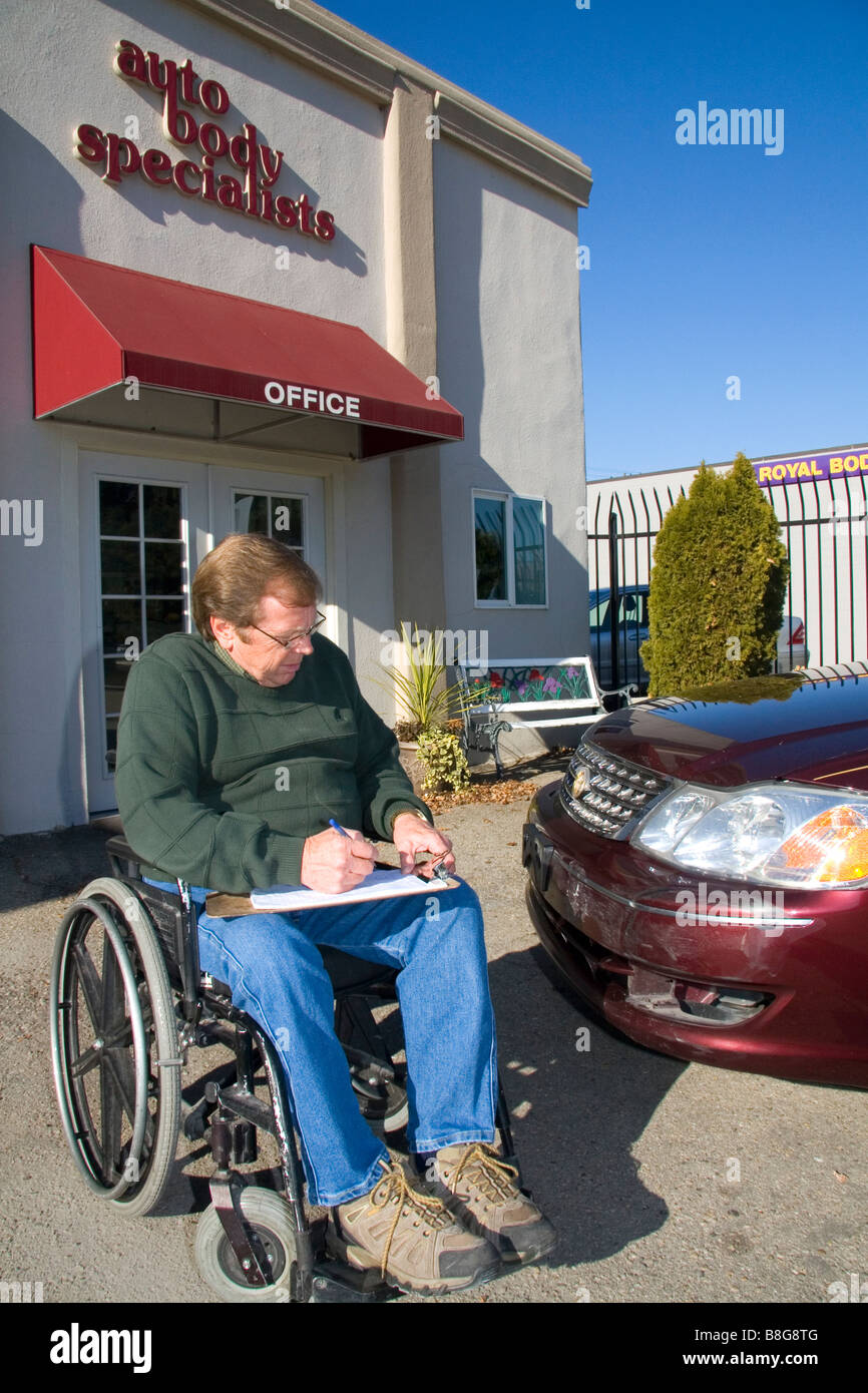 Handicapped insurance claims adjuster assessing the damage of an automobile in Boise Idaho USA Stock Photo
