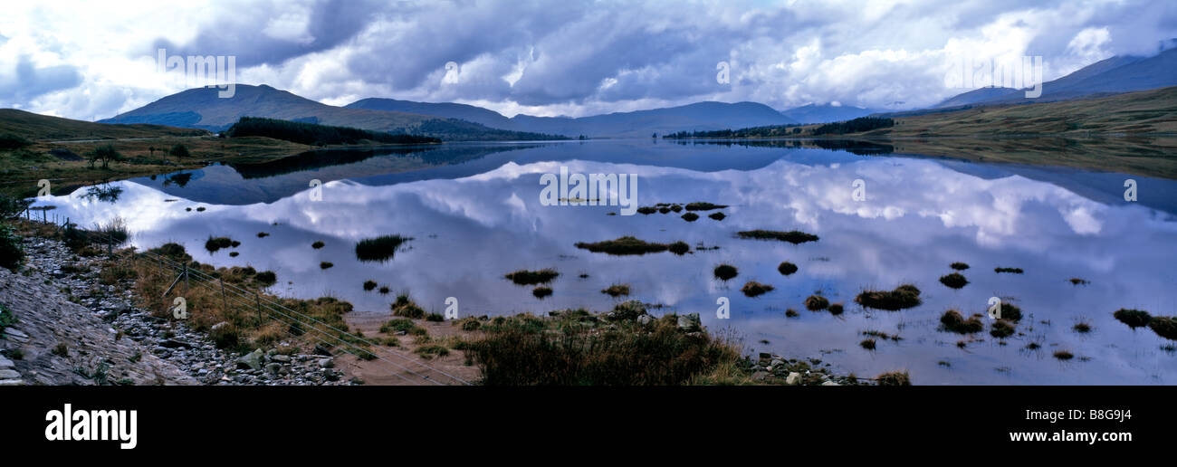 A panoramic view of cloudy sky over the peaceful water of Loch Tulla on Rannock Moor Stock Photo