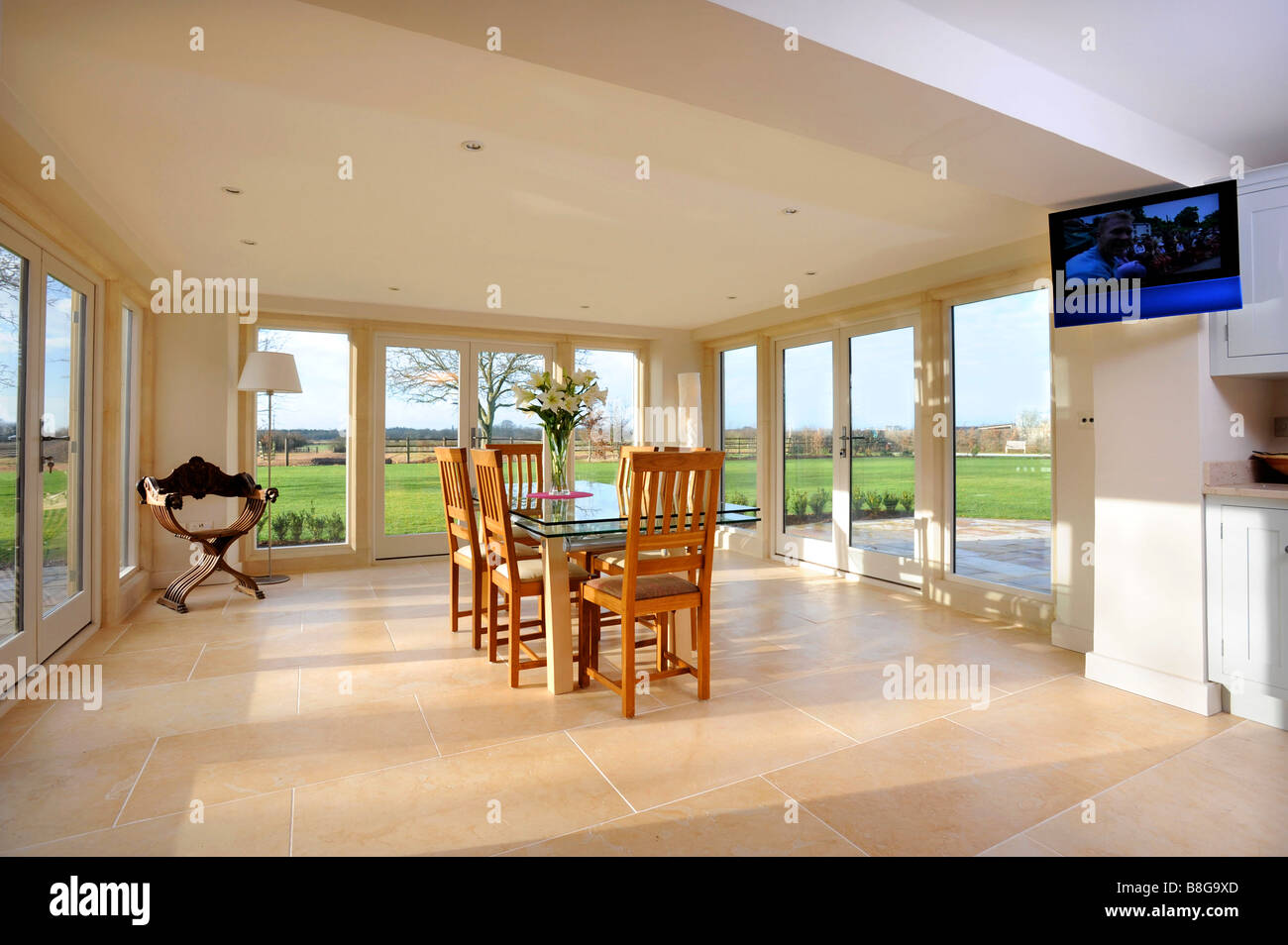 A DINING ROOM SURROUNDED BY PATIO DOORS IN A MODERN COUNTRY HOME UK
