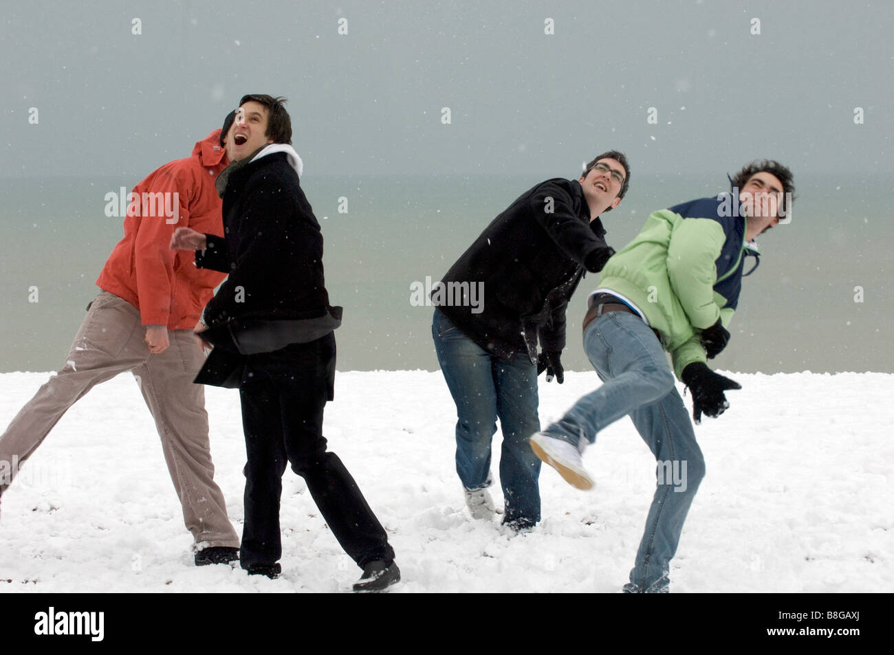 Four young lads enjoying a snowball fight and larking about. Stock Photo