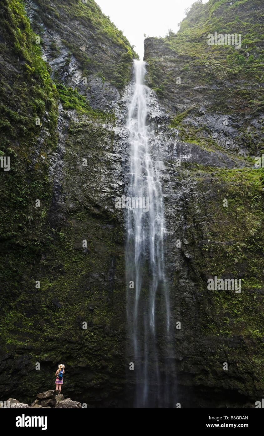 Woman at the base of Hanakapi ai Falls in the Hanakapi ai Valley on the Na Pali Coast of Kauai, Hawaii, USA. Stock Photo