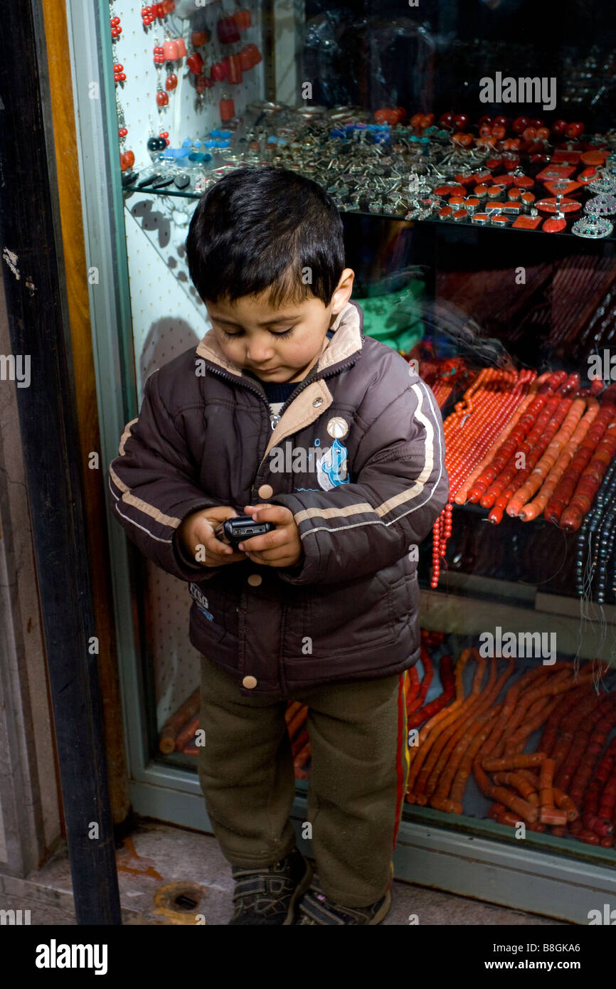 Indian kid checking his mobile phone in Palermo, Sicily, Italy. Stock Photo