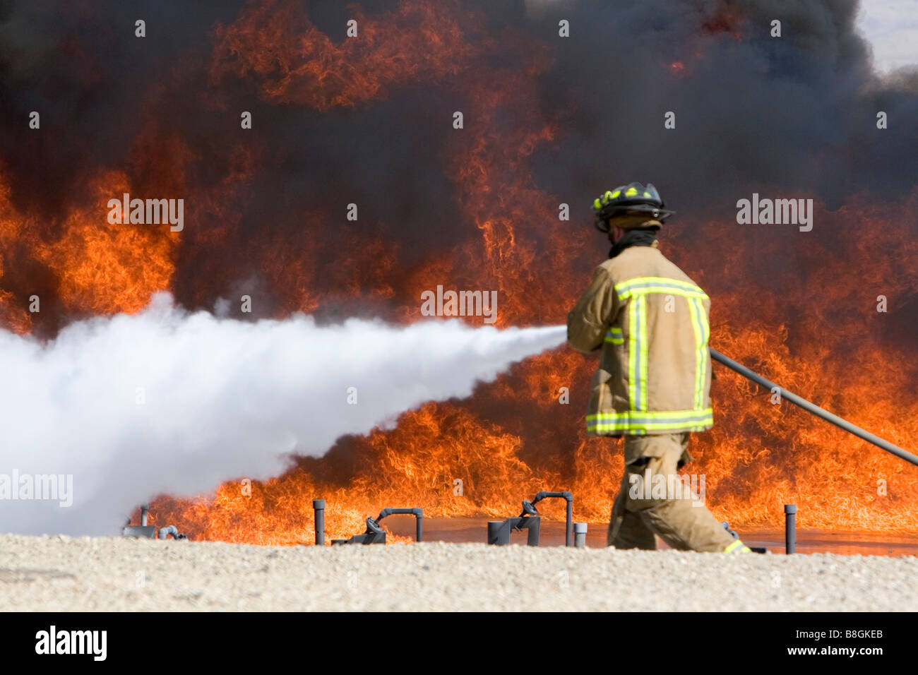 Firefighter using fire retardant foam to put out a jet fuel fire at an airport training facility in Boise Idaho USA Stock Photo